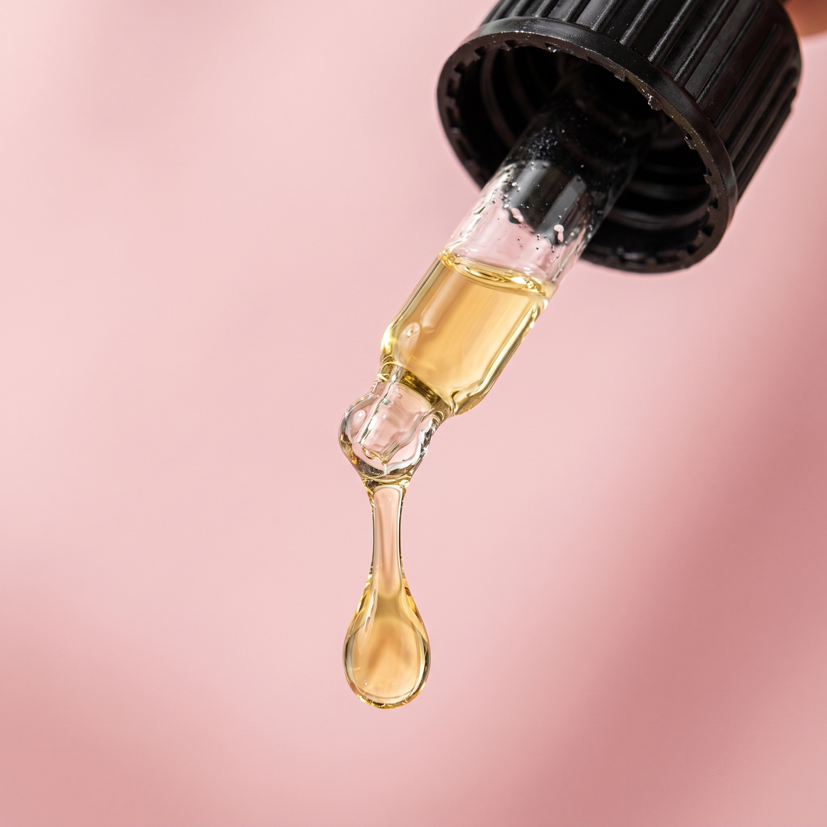 Gotero con una gota de serum a punto de caer